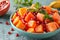 Vibrant tropical fruit salad ingredients on green backdrop for healthy bowl of mixed fruits