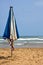 Vibrant umbrella stands in stark contrast to the blue skies and turquoise waters on a beach