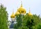 Vibrant view of golden cupola of famous orthodox church among green trees in Dmitrov