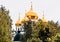 Vibrant view of golden cupola of famous orthodox church among green trees in Dmitrov