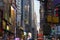 Vibrant view of neon signs, ads and Chrysler Building in background at dusk