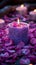 Vibrant violet candle amidst delicate pink and purple flower petals