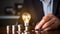 Vibrant Vision: Light Bulb Grasped by Hand Over Coins on Desk