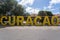 Vibrant yellow sign with the word "Curacao" inscribed on it