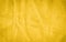 Vibrant yellow texture of binding fabric. Yellow textile background with natural folds.
