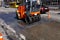 Vibrating orange road roller repairs the road section on a city street