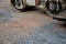 The vibrating roller compresses the aggregate and concrete gravel fragments. it can also roll asphalt. close-up view of a tire and