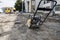 Vibrational paving stone machine for finish on a sidewalk road construction site staying on a ground and stones during