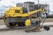 Vibratory rammer with vibrating plate on a construction site. Manual roller. Compaction of the soil before laying paving slabs.