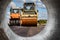 Vibratory road roller lays asphalt on a new road under construction. Close-up of the work of road construction equipment. Modern