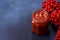 Viburnum fruit jam in a glass jar on a dark concrete background