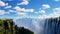 Victoria Falls and Zambezi River against a blue sky, Zimbabwe