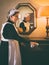 Victorian chambermaid in front of mirror