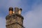 Victorian domestic chimney with four assorted chimney-pots against a clear blue sky background. Copy space