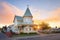 victorian home with bay window at sunset