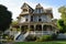 victorian house with wrap-around porch, and wicker rocking chairs