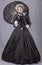 Victorian woman in a black bodice, skirt, parasol and bonnet