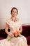 Victorian woman sitting holding flower bouquet