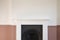 Victorian wooden fireplace surround with white and pink walls