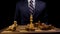 Victorious Business Leader in Suit Pounds King Chess Piece on Wooden Game Board