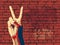 The Victory sign with red brick wall background.