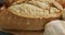 Video of bread on chopping wooden board on wooden worktop