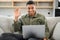 Video call concept. Multiracial freelancer man waving hello into laptop webcam. Black guy connected via video with