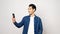 Video call conference, Happy asian man having a video chat on mobile phone while standing on grey background, Asia male talking