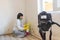 Video camera filming how female worker of cleaning service cleaning mold from wall using spray bottle with mold remediation