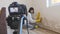 Video camera filming how woman removing mold from wall using spray bottle with mold removal products  and scrubbing brush