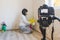 Video camera filming woman removing mildew from wall using spray bottle with mold remediation chemicals