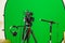 Video camera on a tripod, headphones and a directional microphone on a green background. The chroma key. Green screen
