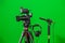 Video camera on a tripod, headphones and a directional microphone on a green background. The chroma key. Green screen