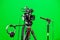 Video camera on a tripod, headphones and a directional microphone on a green background. The chroma key. Green screen