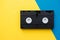 Video cassette on yellow and blue background. Top view. VHS videotape. Minimalistic retro concept