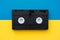 Video cassette on yellow and blue background. Top view. VHS videotape. Minimalistic retro concept. Copy, empty space for text