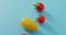 Video of close up of four fresh cherry and yellow tomatoes with copy space on blue background