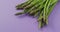 Video of close up of fresh asparagus with copy space over lilac background