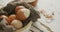 Video of close up of hard boiled brown eggs with cloth in bowl on rustic background