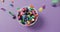 Video of close up of multi coloured sweets falling into bowl over purple background