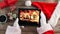 Video composition with snow over desk with santa hand on tablet