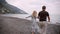 Video of couple on the beach romantic holding hands running playful. Young couple in love enjoying romance in casual