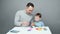 Video of dad and son sculpting in plasticine on gray background