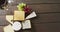 Video of diverse cheeses, grapes and glass of wine on wooden surface