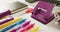 Video of diverse colorful pen, notebook, scissors and punch lying on desk