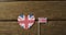 Video of flags of great britain in shape of heart and rectangle on wooden background