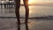 Video footage ,Woman legs on the beach sand waves sea at sunrise