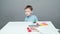 Video four year old boy sculpting in plasticine on gray background