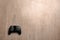 Video game controller on wooden background, top view