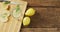 Video of glass with lemonade and lemons on wooden board and wooden surface